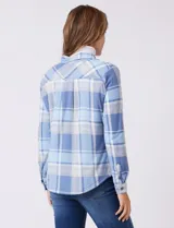 Sobrecamisa de tejido soft con estampado de cuadros en tonos azules y blancos. Presenta cuello con solapa, cierre frontal con botones, bolsillos aplicados en el pecho y mangas largas con puños abotonados. El interior cuenta con un acabado afelpado.