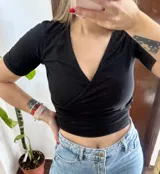 Top negro de manga corta con escote en V cruzado, diseño corto al cuerpo.