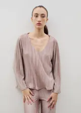 Blusa de tela plisada color rosado, con escote en V y mangas largas semi acampanadas. Presenta un diseño fluido con caída y movimiento.
