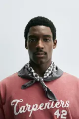 Pañuelo cuadrado de algodón color crema con estampado de cuadros pequeños en tono marrón oscuro.