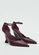 Zapato de tacón color borgoña charolado, con punta fina, tacón de cuña y pulsera al tobillo con hebilla.