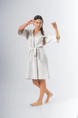 Bata kimono corta color beige, confeccionada en tela waffle de algodón. Tiene mangas al codo, lazo de ajuste en la cintura y detalle de vivo en la solapa.