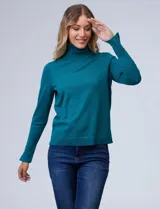 Polera de tejido fino, color rosado, con cuello alto, manga larga y detalle de tajo en los puños.