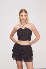 Top gris oscuro con cuello halter, fruncido y con pequeñas tachas.