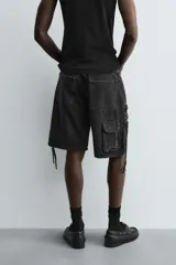 Bermuda de corte relajado en denim de algodón color beige, estilo cargo, con cinco bolsillos y bolsillos plastrón con solapa en las perneras.