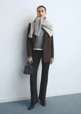 Pantalón de jean estilo flare de tiro medio, con cierre frontal de cremallera y botón, diseño de cinco bolsillos y acabado con bajo desflecado.