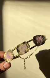 Gargantilla plateada con tres dijes de metal con forma de flor y relleno de piedras blancas.