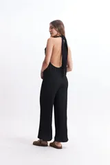 Mono largo negro con escote halter y espalda descubierta.