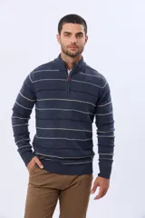 Buzo de algodón tejido color azul marino con rayas horizontales en beige y bordó. Presenta cuello alto con medio cierre frontal y puños y dobladillo acanalados.