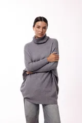 Sweater de punto color gris, con cuello polera amplio y diseño oversize de silueta fluida y caída liviana.