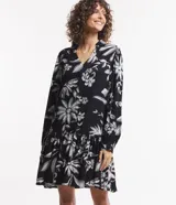 Vestido corto de viscosa con estampado floral en blanco y negro, escote en V, mangas largas con lazo en los puños y volados en el ruedo.