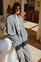 Blazer oversize de corte recto con cuello solapa, manga larga con hombreras y cierre frontal cruzado con botones. Presenta diseño de raya diplomática, bolsillos delanteros y forro interior.