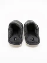 Pantuflas cerradas de estilo clásico, color gris con textura tejida en la parte superior e interior forrado en piel sintética suave. Cuenta con suela de goma y etiqueta de la marca Grego en la plantilla.