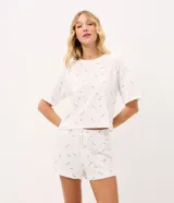 Pijama corto de dos piezas confeccionado en algodón blanco con estampado de palitos chinos. Incluye una remera de manga corta con cuello redondo y un short con cintura elastizada y cordón ajustable.