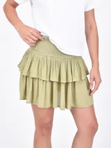Minifalda color verde oliva con diseño de volados escalonados y cintura elástica fruncida.