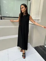 Vestido largo sin mangas, color marrón oscuro o ciruela, de tejido acanalado (morley) con caída amplia.