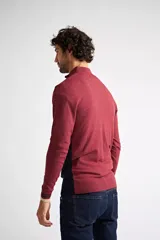 Sweater de tejido de punto con diseño color block en tonos gris, gris claro y negro. Presenta cuello levemente elevado con cierre frontal parcial, mangas largas con puños acanalados y logo bordado en el pecho.