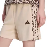Short de felpa color beige de la marca Adidas, con cintura elástica, cordón ajustable interior y bolsillos laterales. Presenta detalles de las tres tiras con estampado animal print en los laterales y el logo de la marca bordado en color marrón en la pierna.