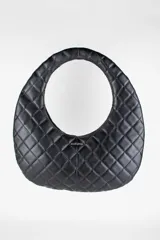 Cartera acolchada negra de silueta ovalada con asa circular integrada y diseño matelassé en rombos.