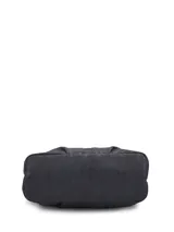Cartera tipo tote bag Hush Puppies modelo Denver, color negro, de diseño estructurado con doble asa superior y bolsillos frontales externos. Cuenta con aplique metálico de la marca y llavero colgante decorativo.