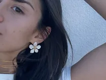 Par de caravanas con forma de flor blanca con centro dorado.