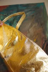 Top corto estilo corset o bandeau, color dorado metálico, con tirantes anchos ajustables.