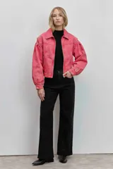 Cazadora de denim en color rosa con efecto lavado, cuello clásico, cierre frontal con cremallera y mangas largas con volumen y puños ajustados.