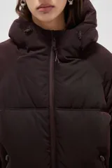 Campera puffer de color marrón oscuro, con diseño capitoneado, cierre frontal, capucha ajustable y bolsillos laterales con cierre.
