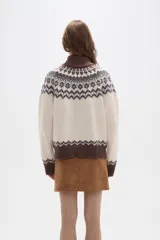 Sweater de punto con diseño jacquard en cuello, puños y ruedo. Presenta cuello alto, mangas largas y corte holgado.
