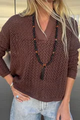 Buzo de tejido de punto calado color marrón oscuro, con cuello en V de color marrón más oscuro.