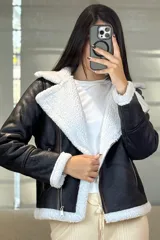 Campera tipo gamulán de cuero sintético negro con interior y solapas de corderito blanco. Presenta cierre frontal cruzado y bolsillos laterales con cierre.