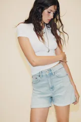 Bermuda de tiro alto confeccionada en denim, con diseño de cinco bolsillos, trabillas para cinturón y bajo con dobladillo vuelto.