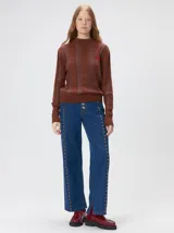 Sweater de punto con diseño de rayas verticales en tonos negro y gris oscuro. Presenta cuello alto tipo polera, mangas largas con puños ajustados y ruedo elástico. Incluye un pequeño bordado en color rojo en el pecho.