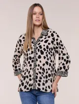 Camisa holgada de rayón con estampado animal print de manchas negras sobre fondo beige, cuello camisero y abotonadura frontal con detalles de estampa estilo cebra. Cuenta con mangas tres cuartos y ruedo curvo.