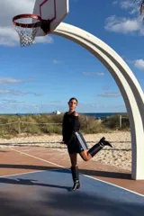 Bota de caña alta confeccionada en cuero negro, con diseño minimalista, punta fina y taco cuadrado de altura media.