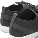 Zapatilla urbana de tejido de punto color gris oscuro, con cordones y suela blanca.