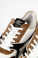 Zapatillas deportivas con diseño moderno en blanco, marrón y negro.