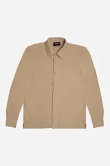 Camisa de manga larga confeccionada en tejido tipo waffle, color beige. Presenta cuello clásico, botonadura frontal y logo de la marca bordado discretamente en el pecho.