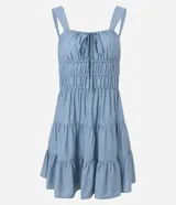 Vestido corto de silueta evasé color celeste, con escote recto y detalle de lazo en el centro. Posee breteles medianos, cintura elástica fruncida y falda con volados escalonados.
