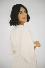 Bata maternal de algodón suave con diseño envolvente, escote en V y lazo ajustable en la cintura. Presenta mangas cortas holgadas y una silueta adaptable ideal para el embarazo y la lactancia.