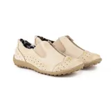 Zapato deportivo de cuero color beige, con perforaciones decorativas, elásticos laterales y cierre frontal con cremallera. Suela de goma texturizada.