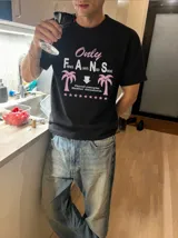 Remera blanca de manga corta, con cuello redondo y diseño gráfico estampado en el pecho que incluye texto y palmeras.