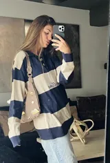 Sweater de punto con cuello polo y botones, a rayas horizontales color marrón y beige.