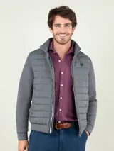 Campera gris marengo con frente acolchado tipo puffer y mangas y espalda de neopreno. Cuenta con cuello alto, cierre frontal y bolsillos laterales.