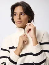 Sweater de punto con diseño a rayas horizontales negras sobre fondo blanco, cuello alto con cierre frontal y mangas largas.
