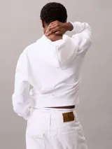 Buzo con capucha Calvin Klein, color blanco, de corte clásico con puños y dobladillo en punto canalé. Presenta cordones ajustables en la capucha y un pequeño logotipo bordado en el pecho.