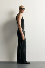 Jeans flare fit de denim negro, tiro medio, ajustados arriba y con botamanga acampanada. Cuentan con cinco bolsillos, lavado efecto gastado y bajo con acabado irregular. Cierre frontal con cremallera y botón.