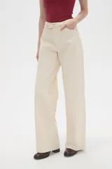 Pantalon de jean de corte ancho y tiro medio, en color natural, con cierre frontal y bolsillos laterales.