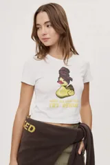 Remera blanca de manga corta con corte ajustado, cuello redondo y estampado frontal de un pato con turbante y texto.