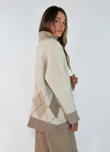 Sweater de cuello alto en color marrón chocolate, con diseño de rombos en la parte inferior en tonos naranja y bordó. Presenta mangas largas con puños acanalados y un corte holgado.